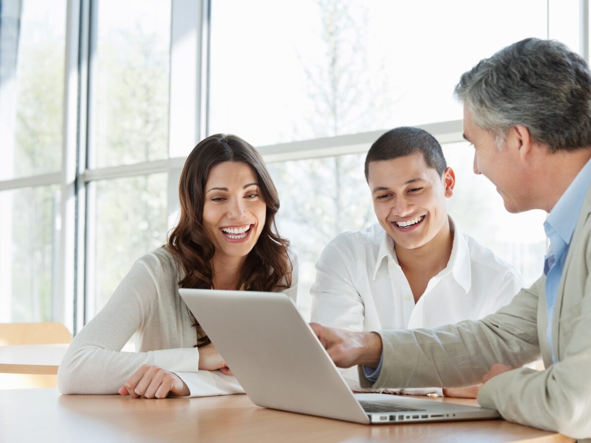 Drei Menschen schauen gemeinsam auf einen Laptop