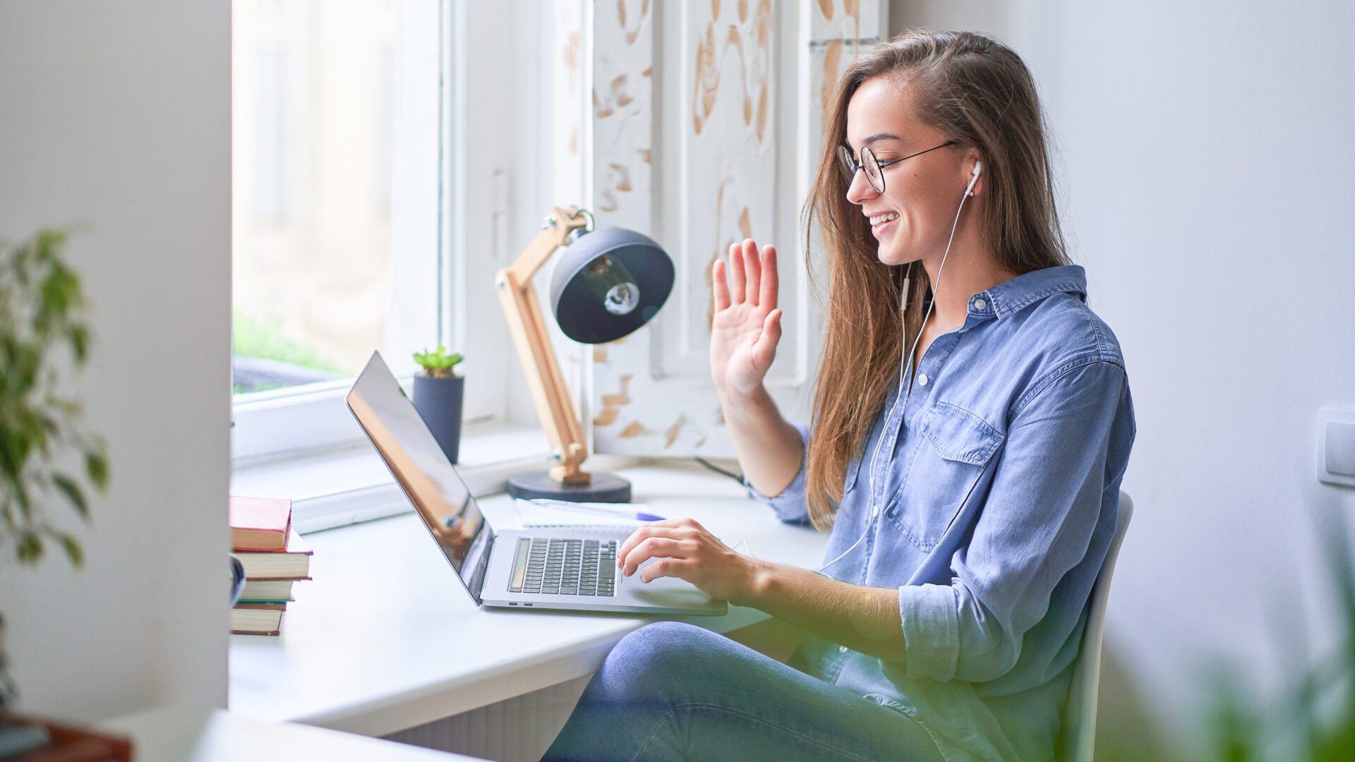 junge frau sitzt vor laptop im home office im video call