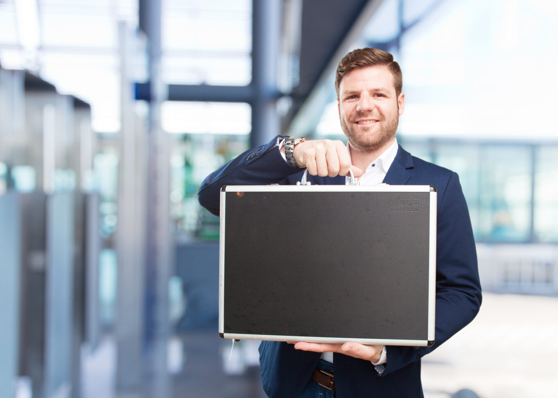 Unternehmer hält einen großen schwarzen Koffer in der Hand